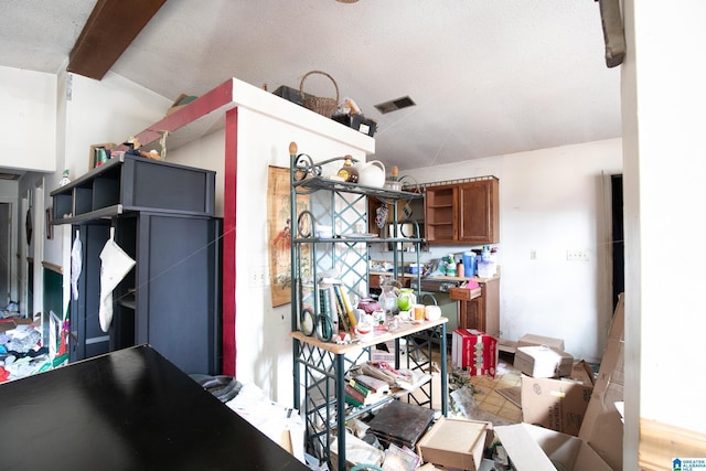 kitchen featuring vaulted ceiling with beams, open shelves, visible vents, and brown cabinets