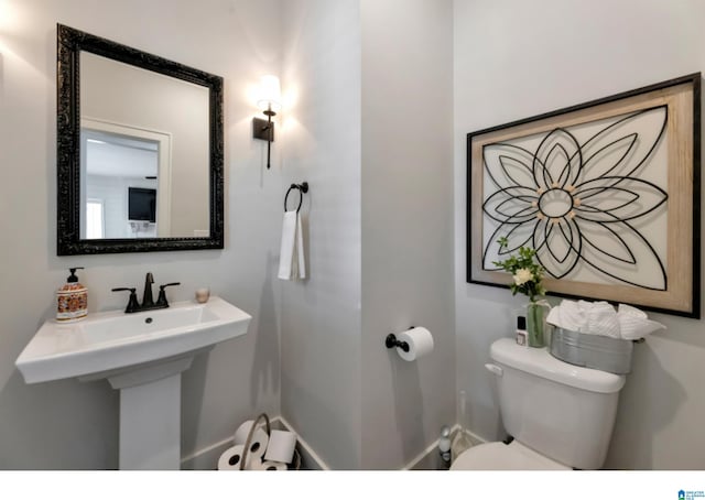 bathroom featuring baseboards and toilet