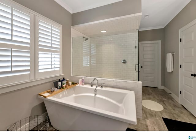 full bathroom featuring visible vents, baseboards, ornamental molding, a soaking tub, and a shower stall