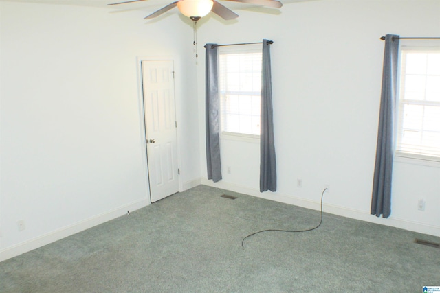 spare room featuring a ceiling fan, baseboards, visible vents, and carpet flooring