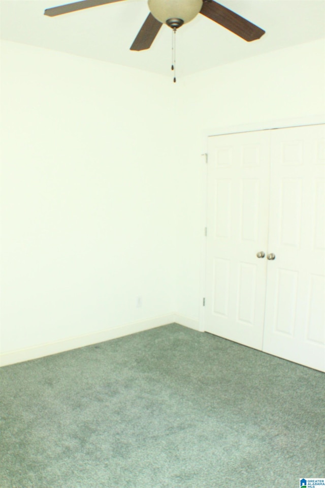 carpeted spare room with ceiling fan and baseboards