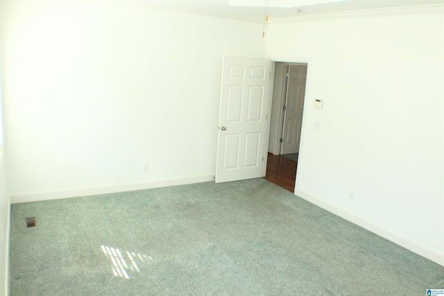 carpeted spare room featuring baseboards and visible vents