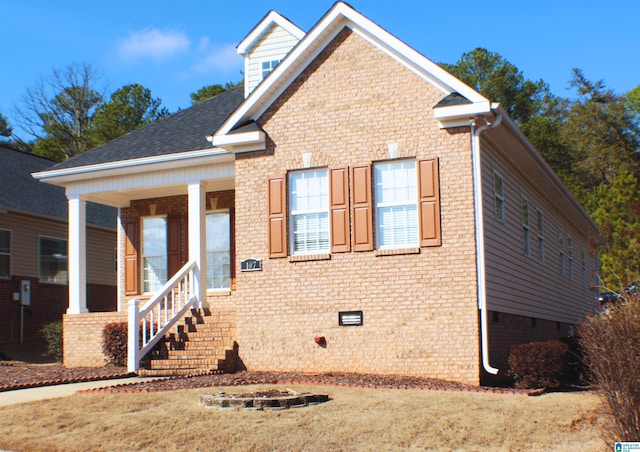 view of front of home with crawl space, a porch, and brick siding