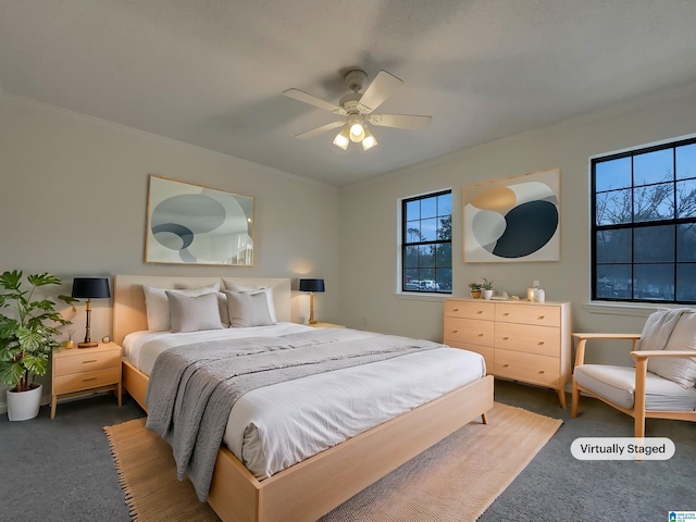 carpeted bedroom featuring multiple windows, ornamental molding, and a ceiling fan