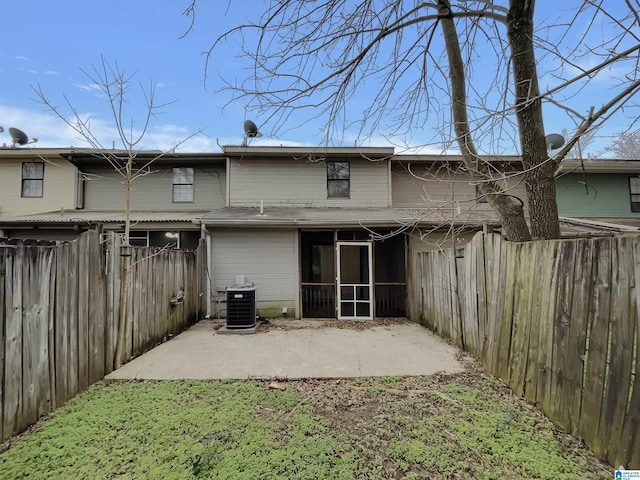 rear view of property featuring a patio area, a fenced backyard, a sunroom, and central air condition unit