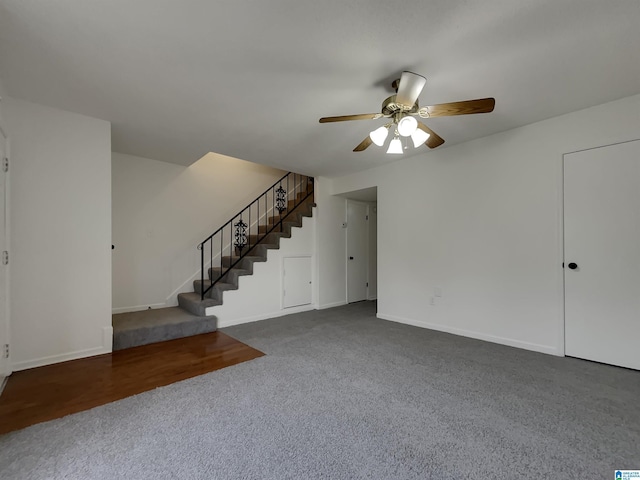 unfurnished living room with stairs, ceiling fan, and baseboards