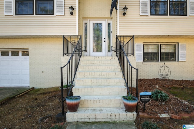 property entrance featuring an attached garage and brick siding