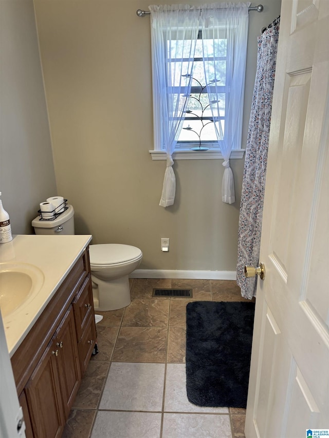 bathroom featuring visible vents, toilet, vanity, and baseboards