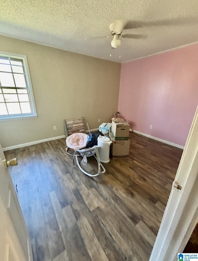 unfurnished bedroom with dark wood-style floors, a textured ceiling, and baseboards