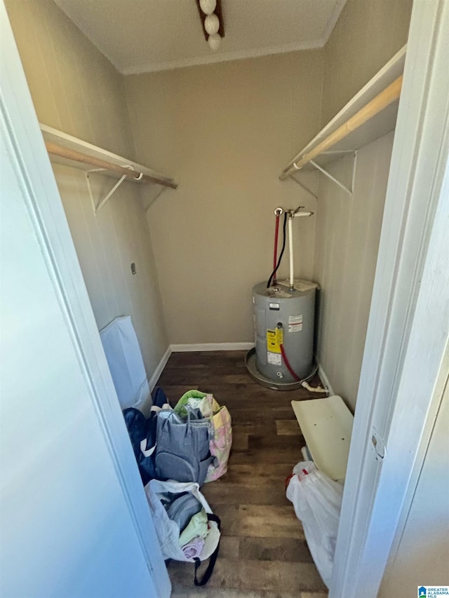 interior space with laundry area, dark wood-style flooring, baseboards, water heater, and electric dryer hookup