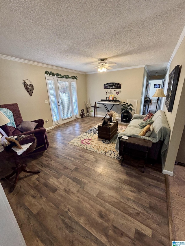 living area featuring dark wood finished floors, ornamental molding, ceiling fan, a textured ceiling, and baseboards