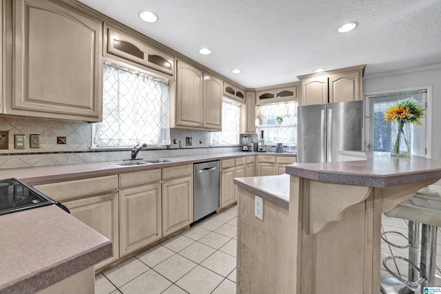 kitchen featuring a kitchen island, appliances with stainless steel finishes, a breakfast bar, and light brown cabinetry