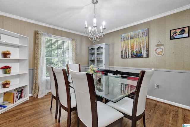 dining area with ornamental molding, dark wood finished floors, and a notable chandelier