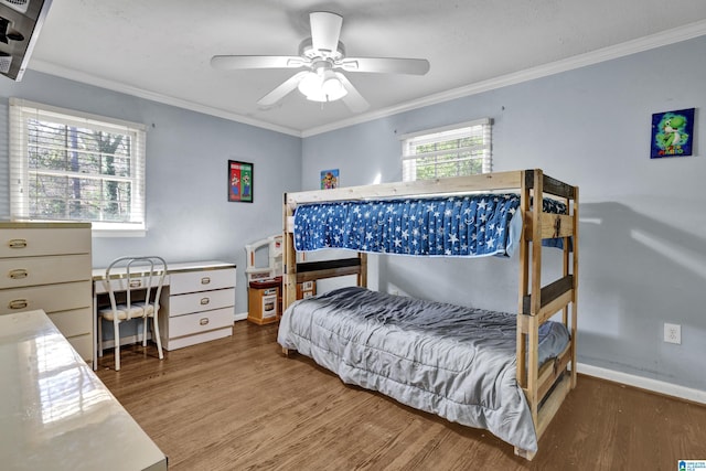 bedroom with baseboards, ornamental molding, and wood finished floors