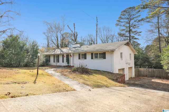 single story home with a garage, driveway, fence, and stucco siding