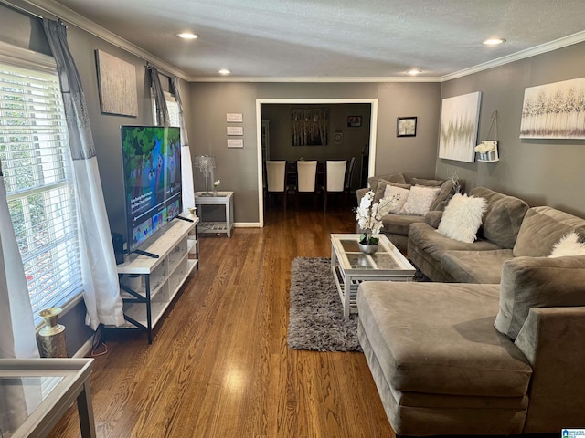 living area with a textured ceiling, recessed lighting, baseboards, ornamental molding, and dark wood finished floors