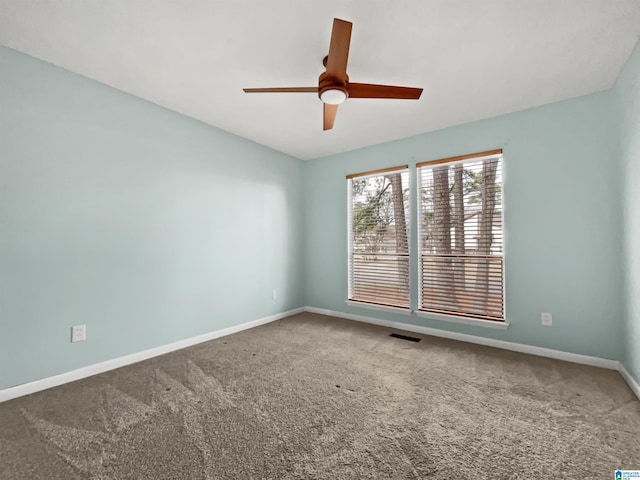 carpeted empty room with a ceiling fan, visible vents, and baseboards