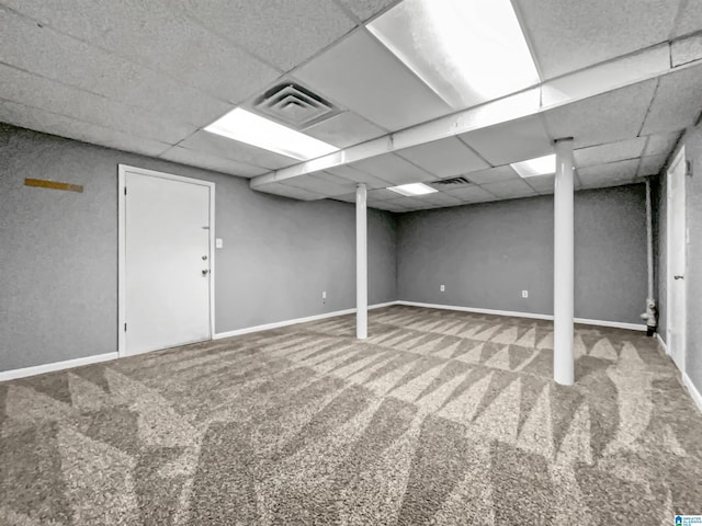 finished basement with carpet floors, visible vents, and a paneled ceiling