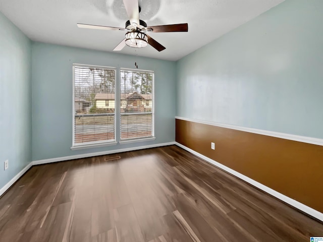 unfurnished room featuring visible vents, ceiling fan, baseboards, and wood finished floors