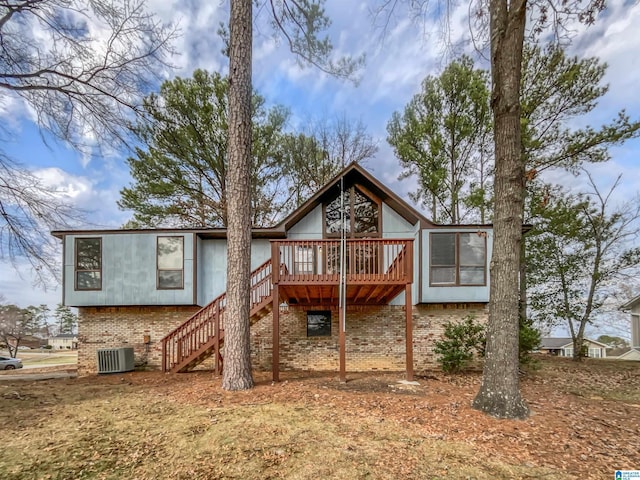 back of house featuring central AC, brick siding, a deck, and stairs