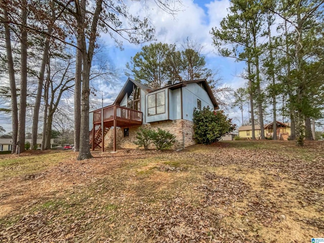 view of side of home with stairs, a deck, and brick siding