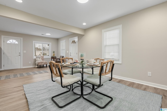 dining room with light wood-style floors, recessed lighting, and baseboards