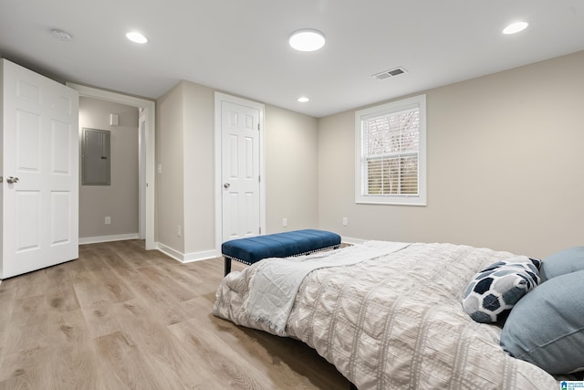 bedroom featuring recessed lighting, visible vents, baseboards, light wood-style floors, and electric panel