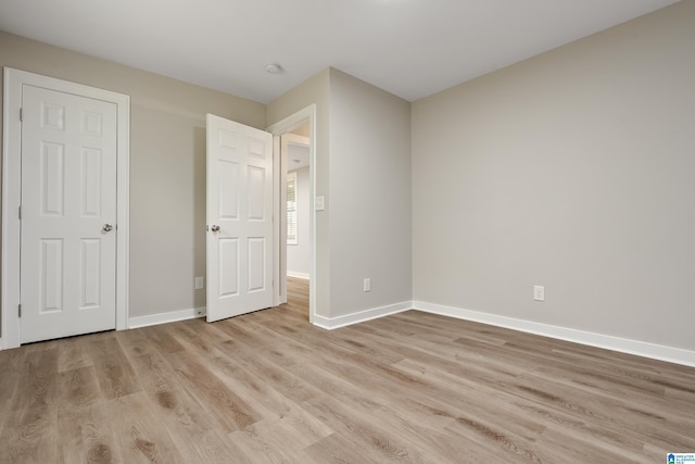 unfurnished bedroom with light wood-style flooring and baseboards