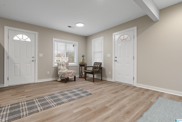 foyer entrance featuring light wood-style flooring, visible vents, and baseboards