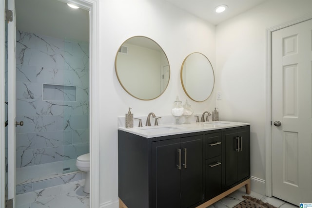 full bathroom with toilet, marble finish floor, double vanity, and a sink