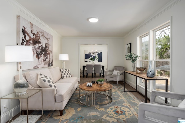 living room featuring ornamental molding, a notable chandelier, baseboards, and wood finished floors