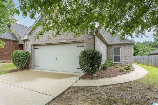 view of front of house with an attached garage, brick siding, a shingled roof, fence, and driveway