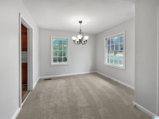 carpeted empty room with a healthy amount of sunlight, visible vents, and baseboards