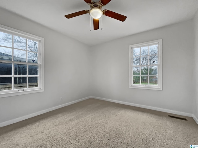 unfurnished room with baseboards, a ceiling fan, visible vents, and a healthy amount of sunlight