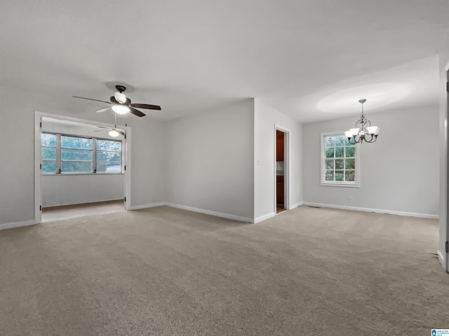 spare room featuring light colored carpet, baseboards, and ceiling fan with notable chandelier