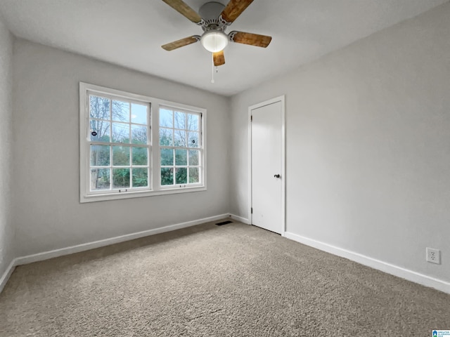 spare room with ceiling fan, carpet flooring, and baseboards