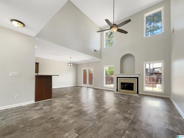 unfurnished living room featuring dark wood finished floors, a fireplace, visible vents, ceiling fan, and baseboards