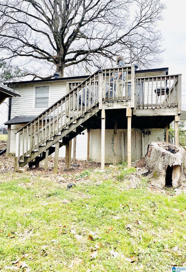 view of side of home featuring stairs, a deck, and a lawn