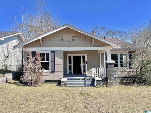 view of front of house featuring covered porch and a front yard