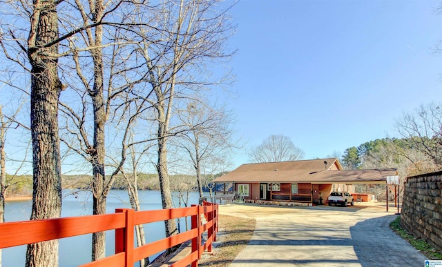 view of street featuring concrete driveway and a water view