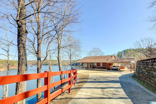 view of street with concrete driveway and a water view