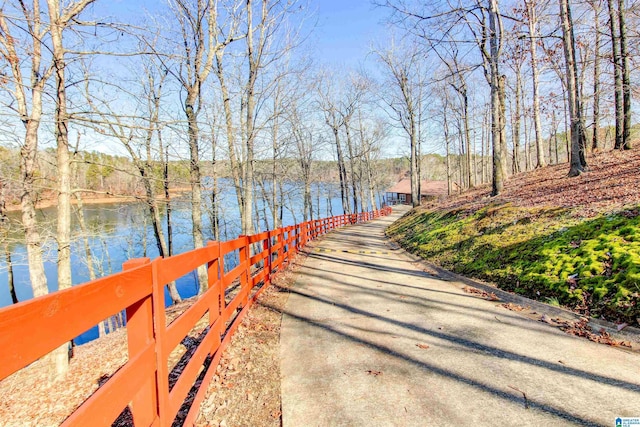 view of dock with a water view and fence