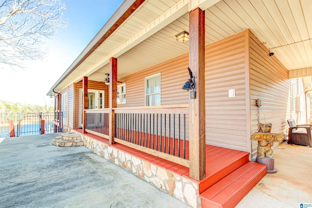 view of side of property with covered porch and fence