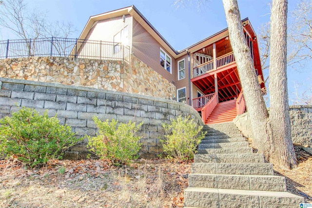 view of side of home featuring stairs and stone siding