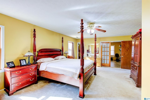 bedroom with french doors, light colored carpet, and ceiling fan