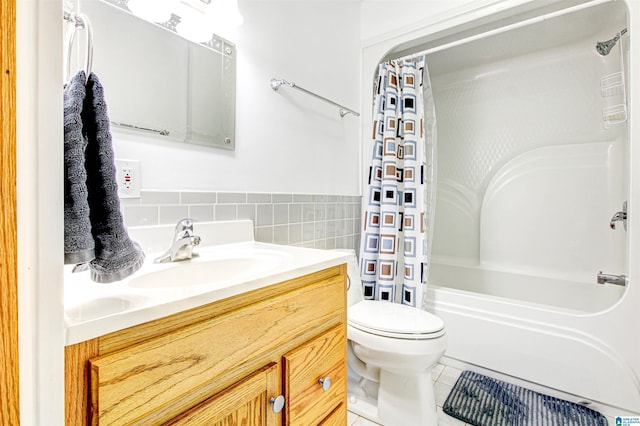 bathroom featuring toilet, tile patterned floors, shower / bath combo with shower curtain, vanity, and tile walls