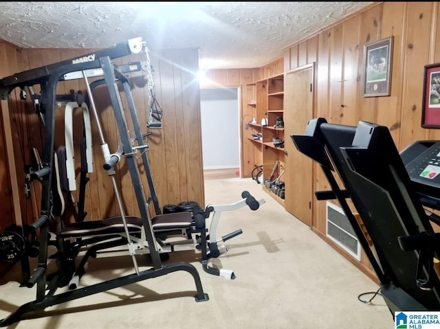 1525 NW Ridge St, Cullman, AL 35055 - workout room with visible vents, carpet floors, a textured ceiling, and wood walls