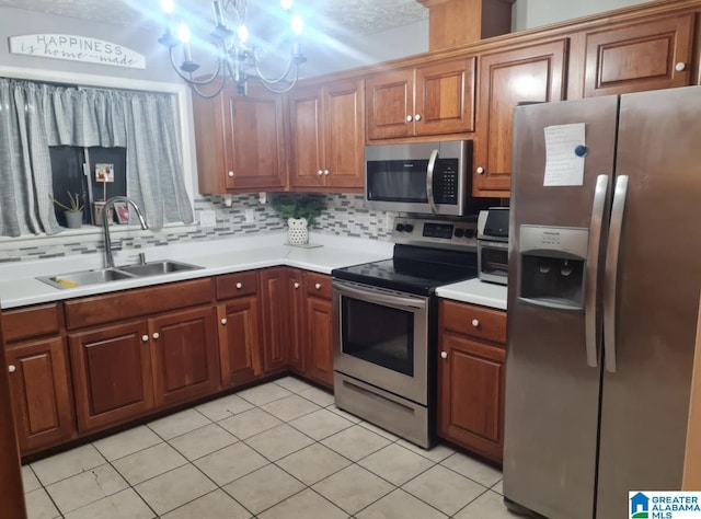 kitchen with light countertops, backsplash, appliances with stainless steel finishes, and a sink