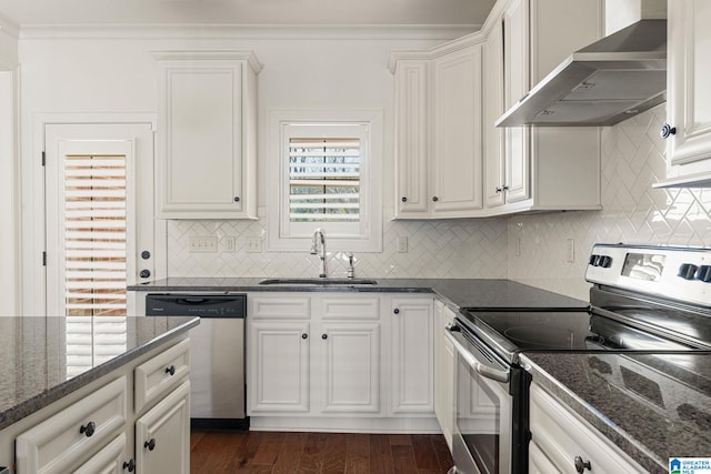 kitchen featuring wall chimney exhaust hood, dark wood-style flooring, stainless steel appliances, crown molding, and a sink