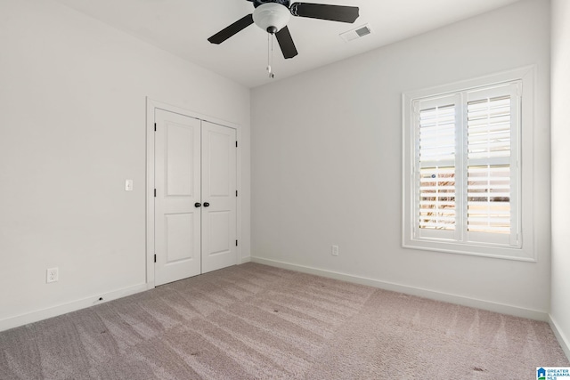 unfurnished bedroom with carpet floors, baseboards, visible vents, and a closet